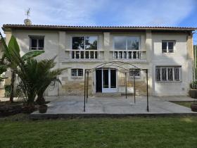 Maison en pierre sur un terrain arboré avec petit étang poissonneux